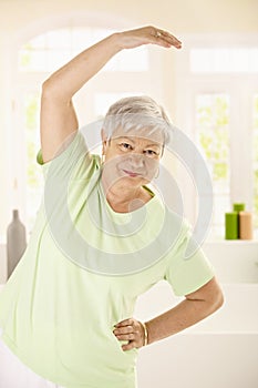 Healthy elderly woman training at home