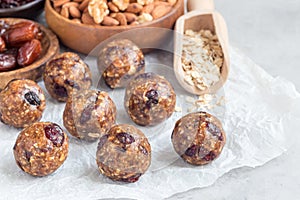 Healthy energy balls with cranberries, nuts, dates and rolled oats on parchment, horizontal, copy space