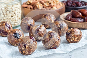 Healthy energy balls with cranberries, nuts, dates and rolled oats on parchment, horizontal