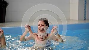 Healthy family mother teaching baby swimming pool