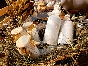 Healthy farm products. Aluminum cans and glass bottles with fresh natural milk on the hay in the hayloft of a dairy farm