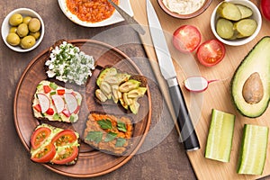 Healthy fast food. Vegan, vegetarian sandwiches with hummus, tomato, avocado, cottage cheese, vegetables and greens. Top view