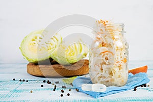 Healthy fermented vegetables in glass jars on a wooden background.