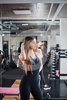 Healthy and fit woman in sport clothes posing at gym