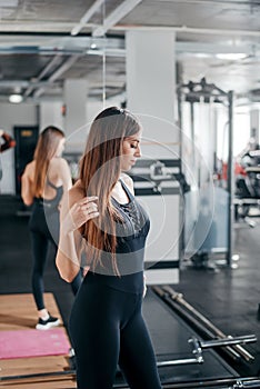 Healthy and fit woman in sport clothes posing at gym