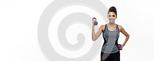 Healthy and Fitness concept - Beautiful American African lady in fitness clothes workout with dumbbell. Isolated on