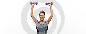 Healthy and Fitness concept - Beautiful American African lady in fitness clothes workout with dumbbell. Isolated on