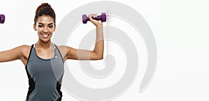 Healthy and Fitness concept - Beautiful American African lady in fitness clothes workout with dumbbell. Isolated on