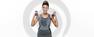 Healthy and Fitness concept - Beautiful American African lady in fitness clothes workout with dumbbell. Isolated on