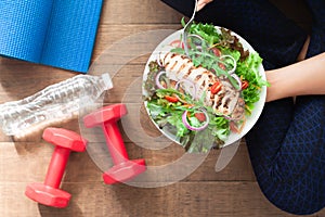 Healthy and fitness food. Chicken salad dish with fitness equipments