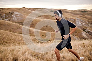 Healthy Fitness Male In Headphones Enjoy Running In Early Morning, Alone, In Nature