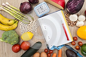 Healthy food around a notebook and a clock with a wooden background