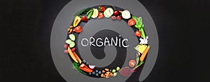 Healthy food background. Circle of fresh vegetables, fruits, nuts, berries with handwritten phrase Organic on black