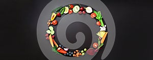 Healthy food background. Circle of organic vegetables, fruits, nuts, berries with copy space on black chalkboard. Top