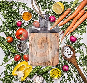 Healthy food background with colorful various vegetables for tasty cooking around the cutting board place for text, frame on woode