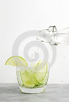 Healthy food background: cucmber and lime detox soda water. Vegetarian food concept