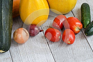 Healthy Food Background. Different Fresh Vegetables On A Wooden White Table. Tomatoes, Zucchini, Eggplant, Onion. Angle