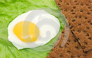 Healthy food background: fried eggs, lettuce, crisp bread