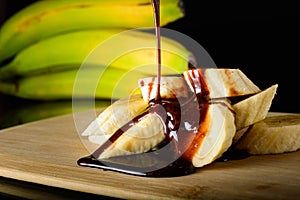 Healthy food bananas sprinkled with chocolate. Food on dark background.