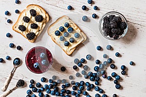 Healthy food. blueberry smoothie and sandwiches with berries on white wooden background.