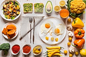 Healthy food for Breakfast. Fried eggs, vegan avocado sandwiches, veggies salad, boiled pumpkin, carrot fresh juice and