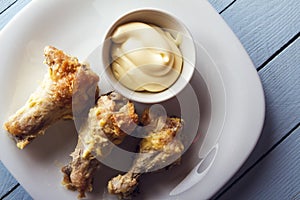 Healthy food from chicken wings with homemade mayonnaise on wooden table. Top view. Copy space