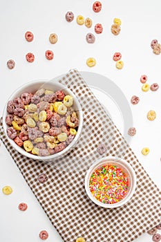 Healthy food concept, Colorful ring cereal in bowl and sugar topping in mini bowl on gingham cloth