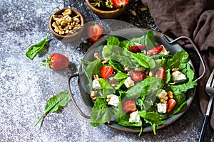Healthy food concept, Diet salad plate. Summer salad with strawberries, fetacheese and walnut