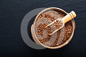 Healthy food concept Organic Flax seeds in ceramic bolw on black slate board with copy space