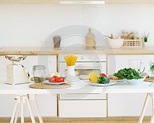 Healthy food for cooking italian pasta and vegetables on kitchen table in modern light apartment