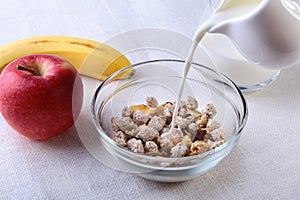 Healthy food with Corn Flakes cereal in a bowl, apple, banana and glass with milk. Morning breakfast.