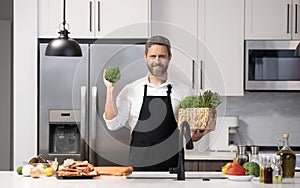 Healthy food for dinner. Man cooking home food. Healthy food, cooking concept. Mature man in apron choose ingredient