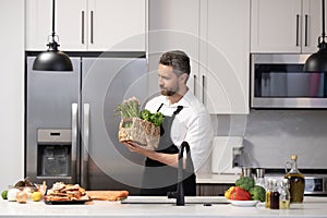 Healthy food for dinner. Man cooking home food. Healthy food, cooking concept. Mature man in apron choose ingredient