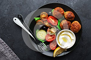 Healthy food dish. Juicy meatballs, fresh vegetables, tomatoes, cucumbers, olives, herbs, herbs with yogurt sauce with