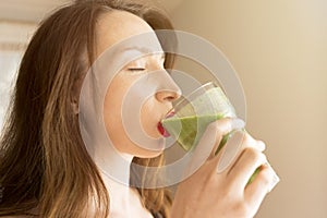 Healthy food and eating concept. happy young woman drinking green detox vegetable smoothie. healthy lifestyle. Health care and be