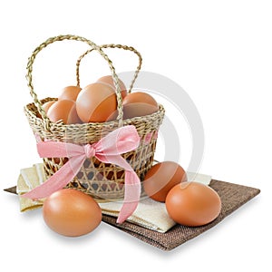 Healthy food,  fresh chicken eggs in basket decorated with pink ribbon on white background