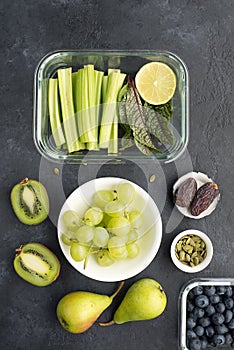 Healthy food fresh ingredients vegetables fruit berries seeds. Glass containers for lunch with juicy celery, lime