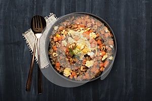 Healthy food garlic fried rice with egg carrot in black bowl on background