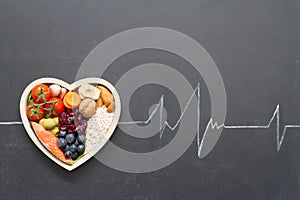 Healthy food in heart and cardiograph on blackboard