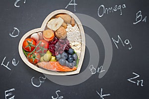 Healthy food in heart and chemical elements on blackboard