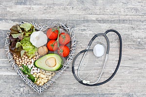Healthy food in heart and cholesterol diet concept on wooden backgraund with stethoscope