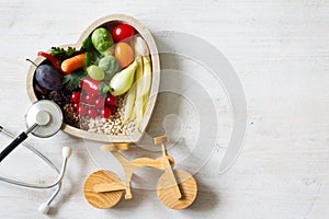 Healthy food in heart with stethoscope and bike diet sport lifestyle concept