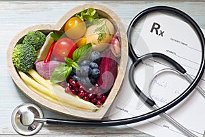 Healthy food in heart stethoscope and medical prescription diet and medicine concept