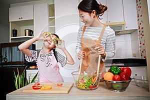 Healthy food at home. Happy family in the kitchen. Mother and child daughter are preparing salad