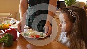 Healthy food at home. Happy family in the kitchen. Mother and child daughter are preparing the vegetables