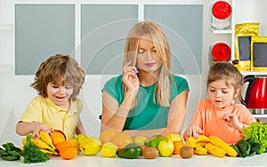 Healthy food at home. Happy family in the kitchen. Mother and children are preparing the vegetables and fruit. Healthy