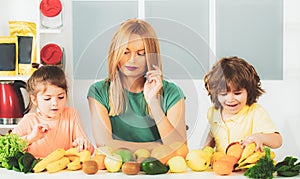 Healthy food at home. Happy family in the kitchen. Mother and children are preparing the vegetables and fruit. Healthy