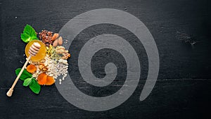 Healthy food. Honey, nuts, oatmeal, dried fruits and dried apricots, flax, sunflower seeds. On a wooden background.