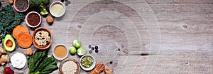 Healthy food ingredients. Above view corner border on a wood banner background. Copy space.