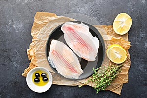 Healthy food ingredients. Fresh sea fish fillet, lemons, spices, salt, herbs, spices for a comfortable diet. Against a